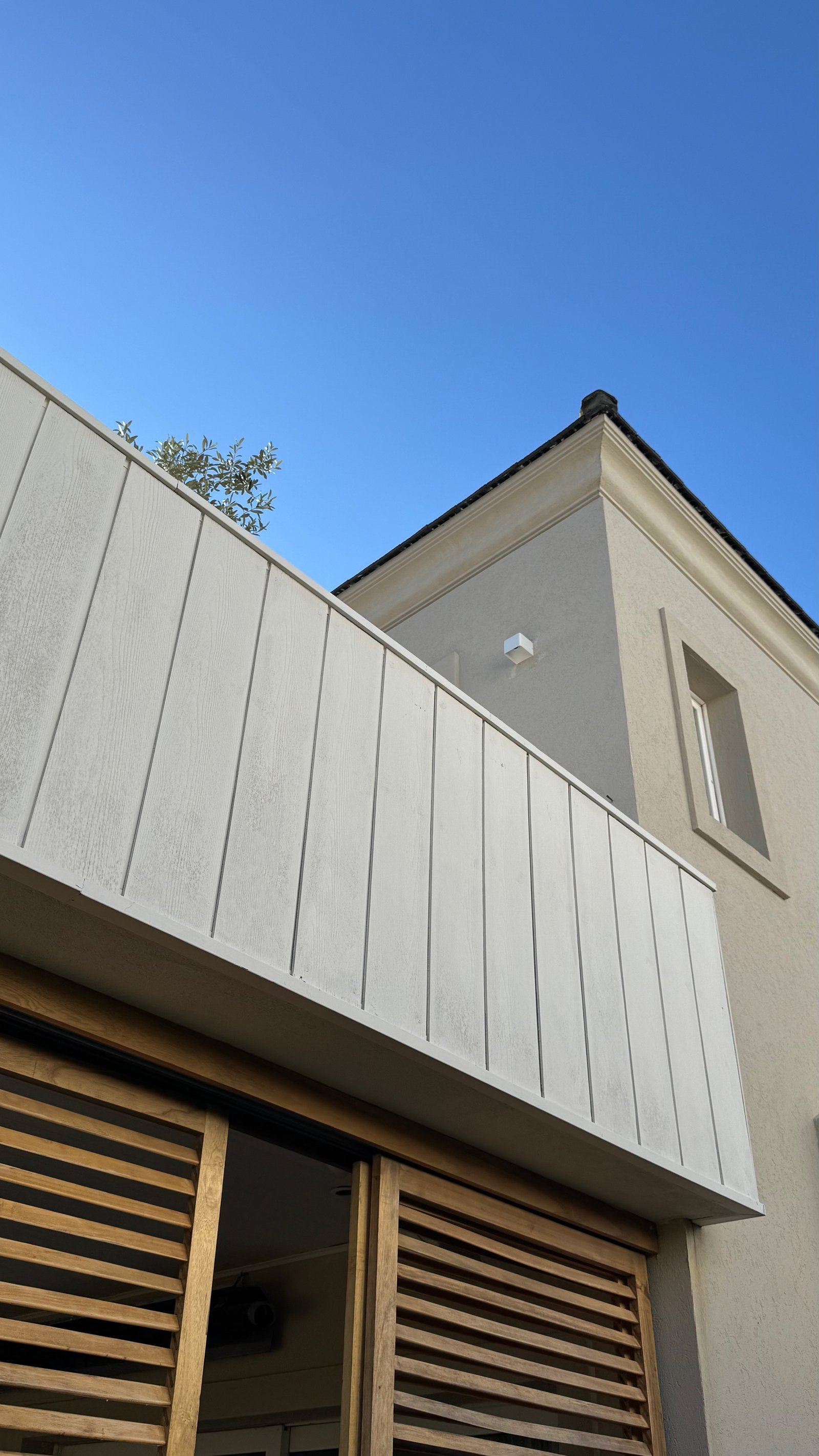 Fachada de casa moderna com revestimento de concreto e madeira — projeto CASA CM, por Hermann Arquitectos, em Los Castores